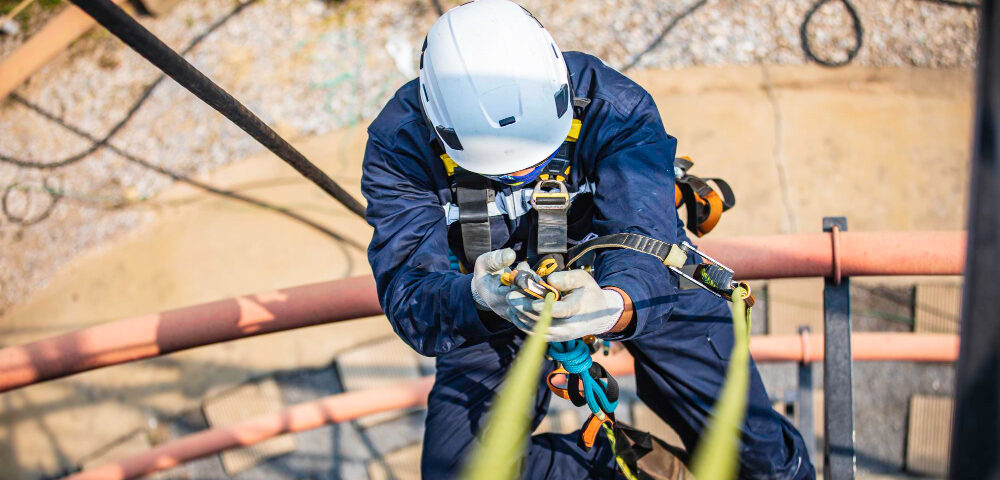 Focus top view male worker down height tank roof rope access safety inspection thickness storage tank