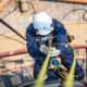 Focus top view male worker down height tank roof rope access safety inspection thickness storage tank
