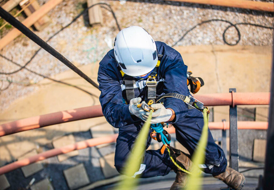 Focus top view male worker down height tank roof rope access safety inspection thickness storage tank